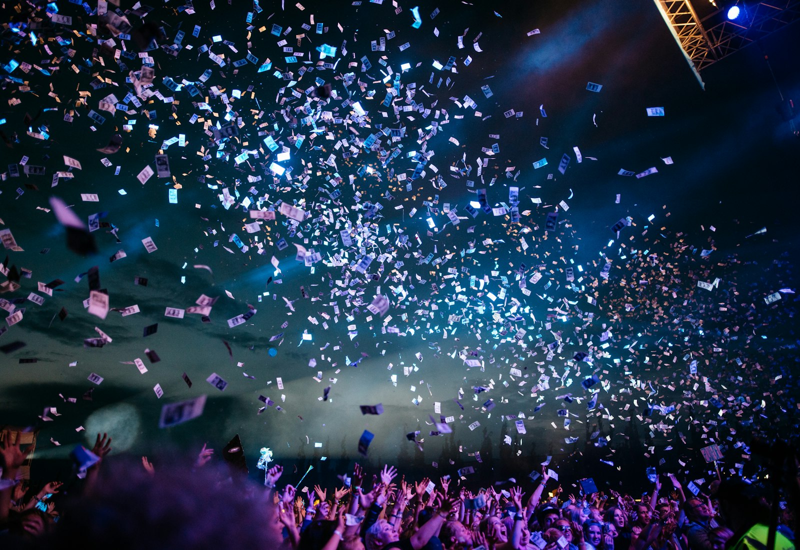 Pista de festa iluminada, com confetti a cair sobre os convidados.